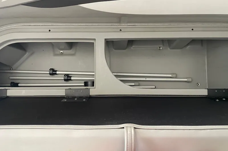 Slide: The Image of Storage compartment in a 2023 Bennington 20 SS boat, featuring metal rods. - 19