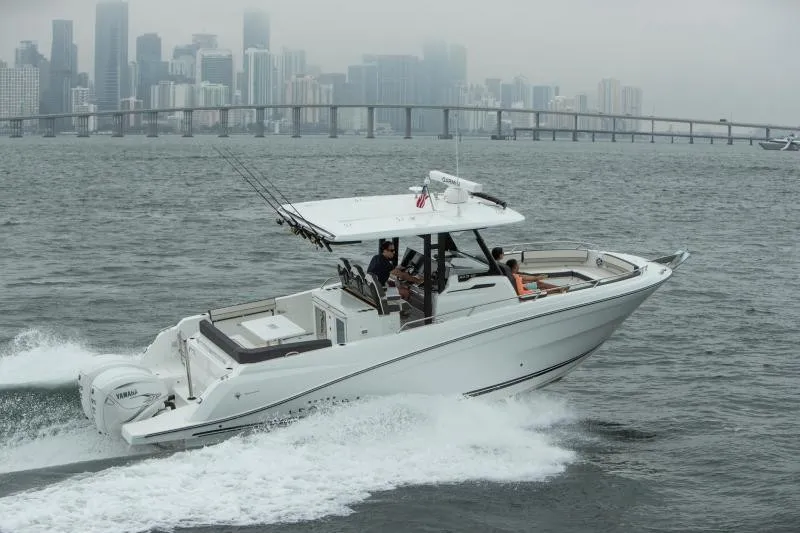 Slide: The Image of A 2026 Jeanneau Leader 10.5 CC cruising on the water with a cityscape in the background. - 17