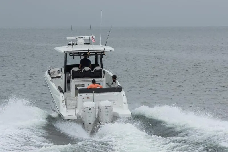 Slide: The Image of A 2026 Jeanneau Leader 10.5 CC boat cruising on the sea with two outboard engines. - 18