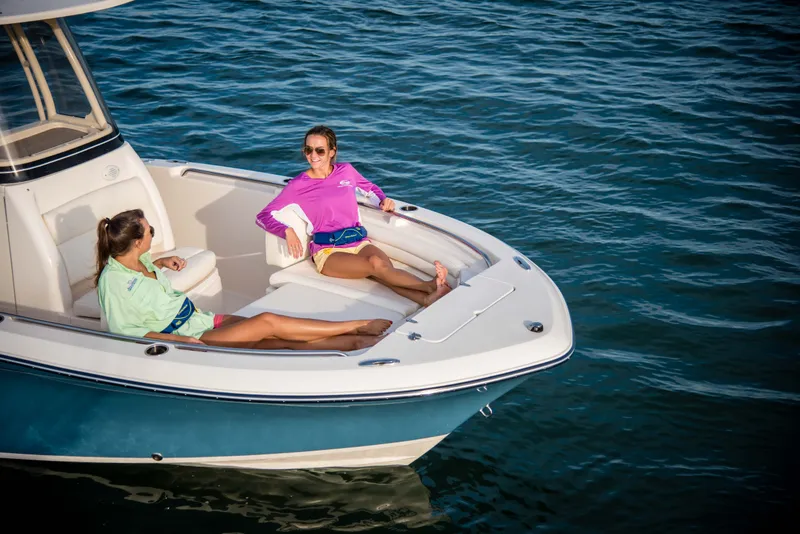 Slide: The Image of Two people relax on the deck of a Grady-White Fisherman 216 boat on calm water. - 10