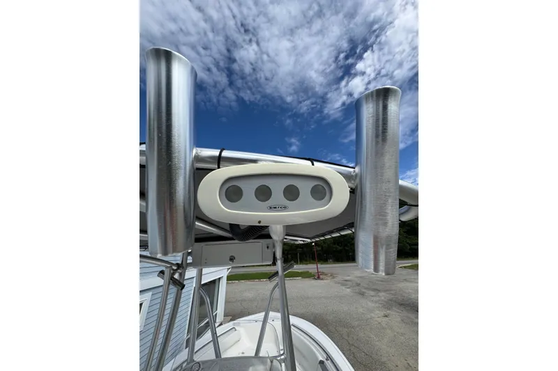 Slide: The Image of 2020 Tidewater 198 CC Adventure boat with rod holders and radar, under a partly cloudy sky. - 8
