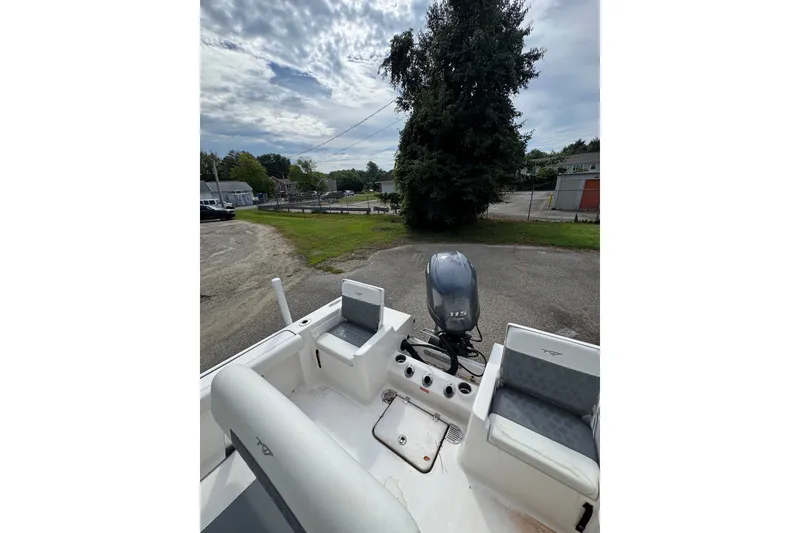 Slide: The Image of 2020 Tidewater 198 CC Adventure boat with outboard motor, parked outdoors under cloudy sky. - 9