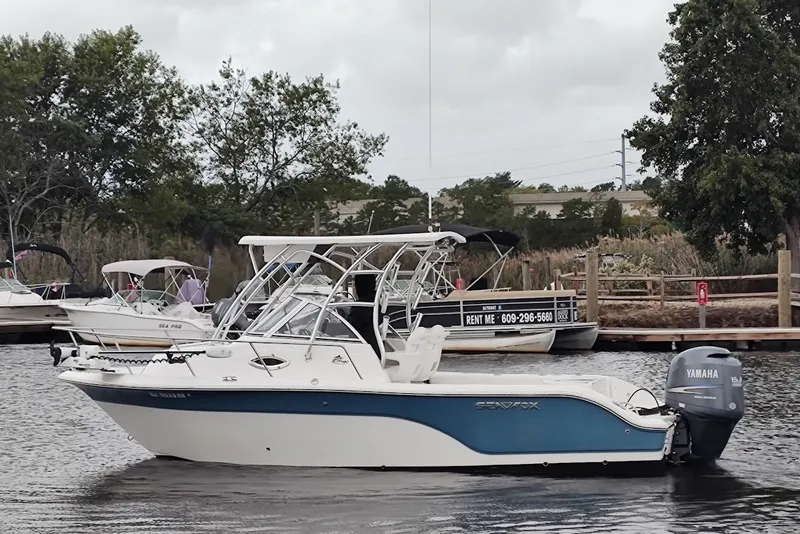 Slide: The Image of 2012 Sea Fox 216 Walk Around boat with Yamaha engine docked on a calm waterway. - 3