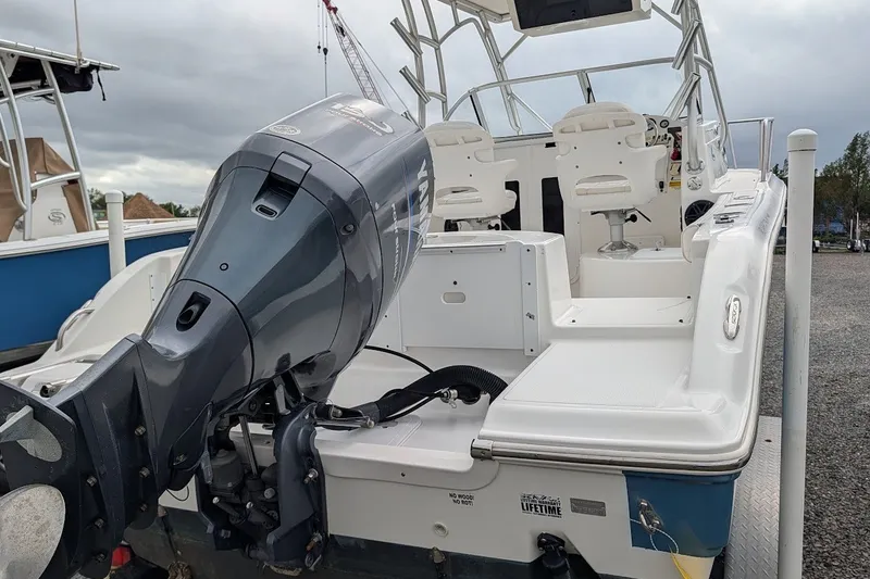 Slide: The Image of 2012 Sea Fox 216 Walk Around boat with Yamaha outboard motor, docked on gravel. - 23