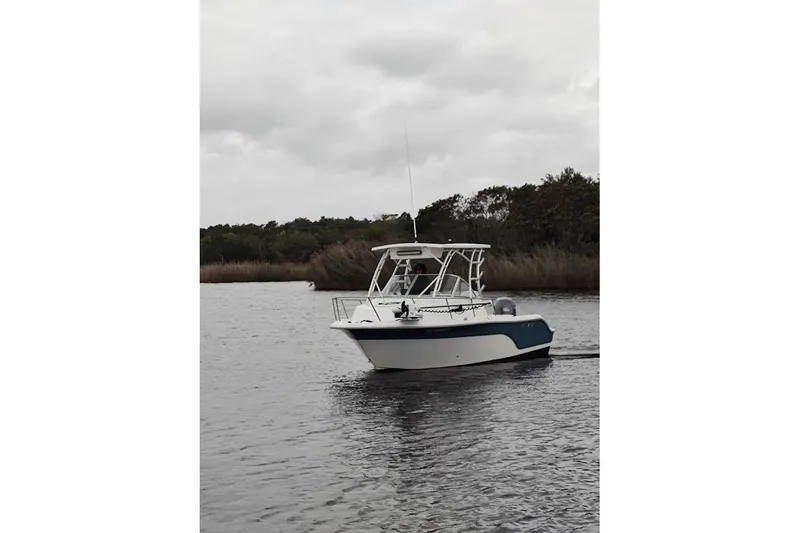 Slide: The Image of 2012 Sea Fox 216 Walk Around boat cruising on a calm river under cloudy skies. - 2