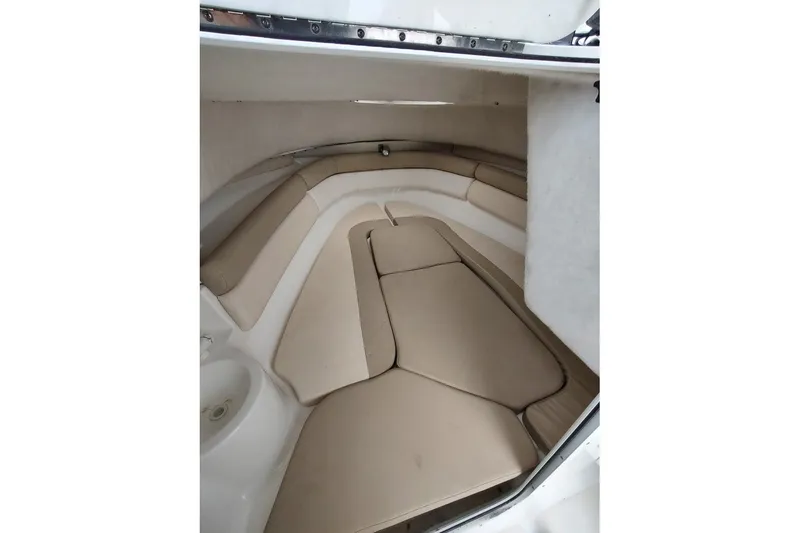 Slide: The Image of 2012 Sea Fox 216 Walk Around cabin interior with beige seating and compact design. - 17
