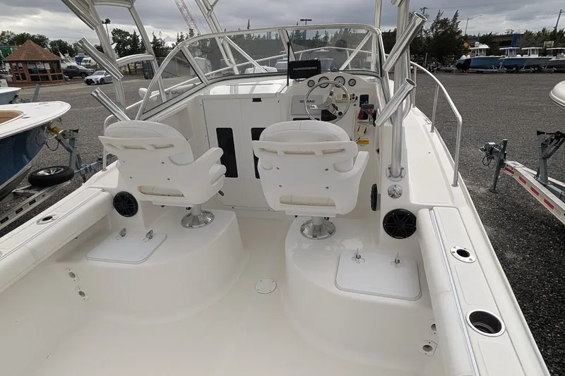Slide: The Image of 2012 Sea Fox 216 Walk Around boat interior with dual white captain chairs and control panel. - 6