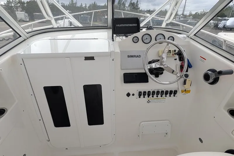 Slide: The Image of 2012 Sea Fox 216 Walk Around boat dashboard with steering wheel and navigation instruments. - 8
