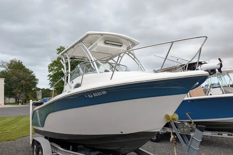 Slide: The Image of 2012 Sea Fox 216 Walk Around boat on trailer, parked outdoors under cloudy sky. - 22