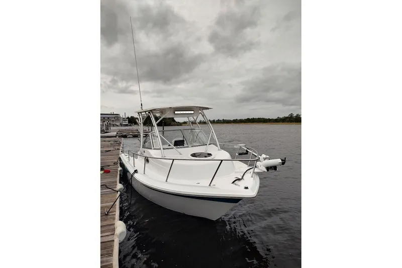 Slide: The Image of 2012 Sea Fox 216 Walk Around boat docked on a cloudy day. - 4