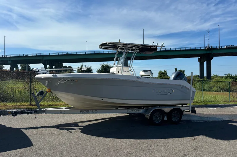 Slide: The Image of 2020 Robalo R200 Center Console boat on trailer, parked outdoors under a clear sky. - 16