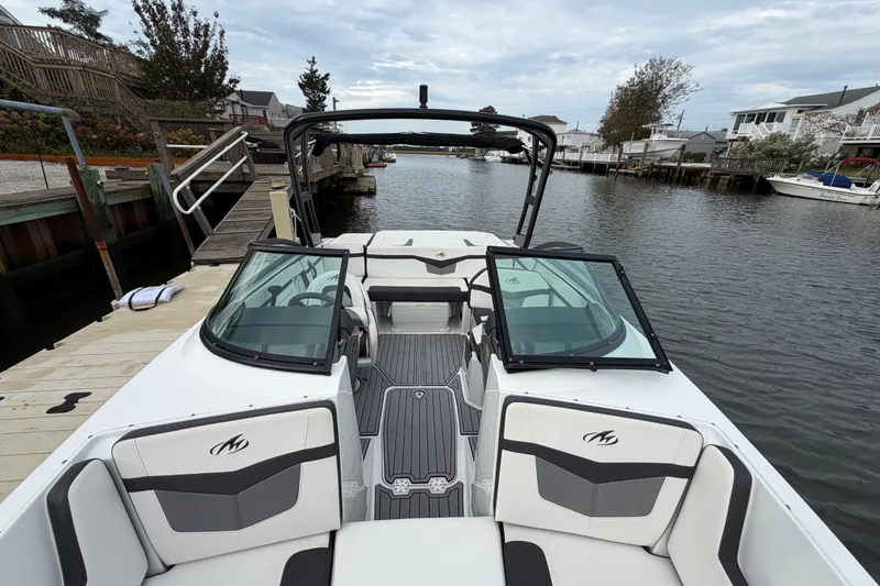 Slide: The Image of 2019 Monterey M-22 boat docked by a wooden pier on a calm waterway. - 27