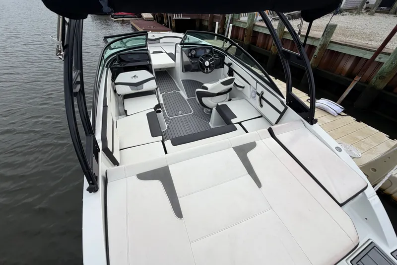 Slide: The Image of 2019 Monterey M-22 boat with spacious seating and sleek design docked by the water. - 18