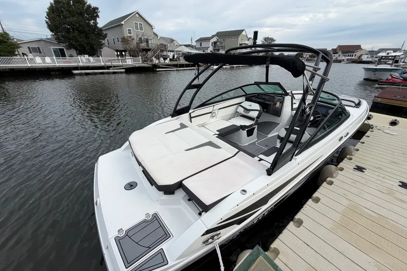Slide: The Image of 2019 Monterey M-22 boat docked in a serene residential canal setting. - 17