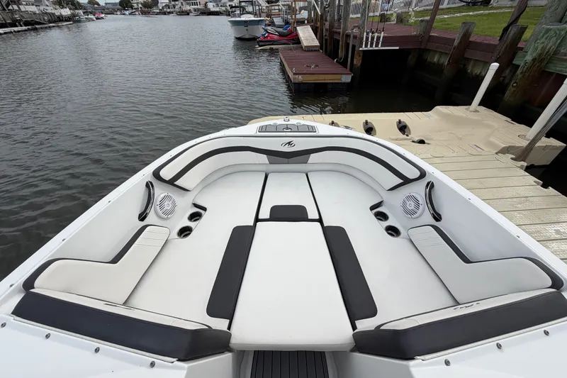 Slide: The Image of 2019 Monterey M-22 boat with spacious seating, docked by a wooden pier. - 26
