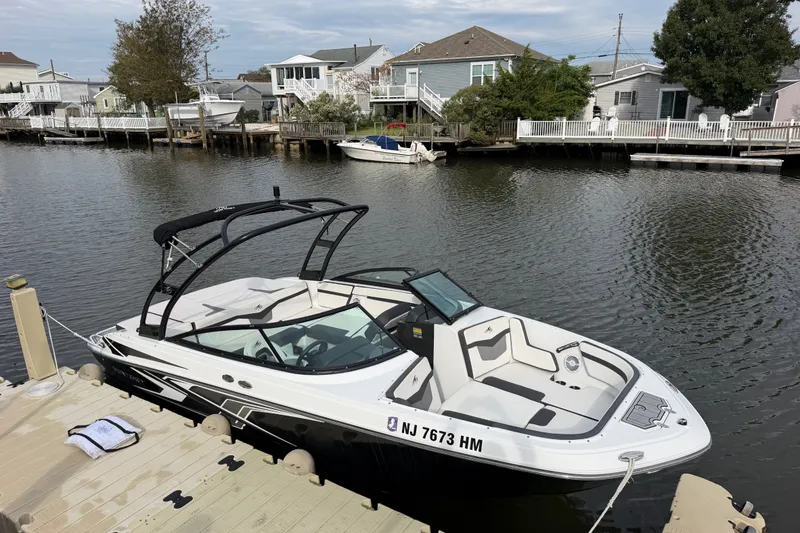 Slide: The Image of 2019 Monterey M-22 boat docked by waterfront homes, featuring sleek design and modern amenities. - 15