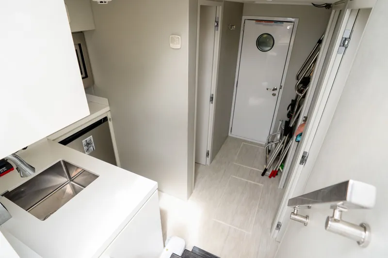 Slide: The Image of Interior of 2018 Hatteras M75 Panacera yacht, featuring compact kitchen and hallway. - 55