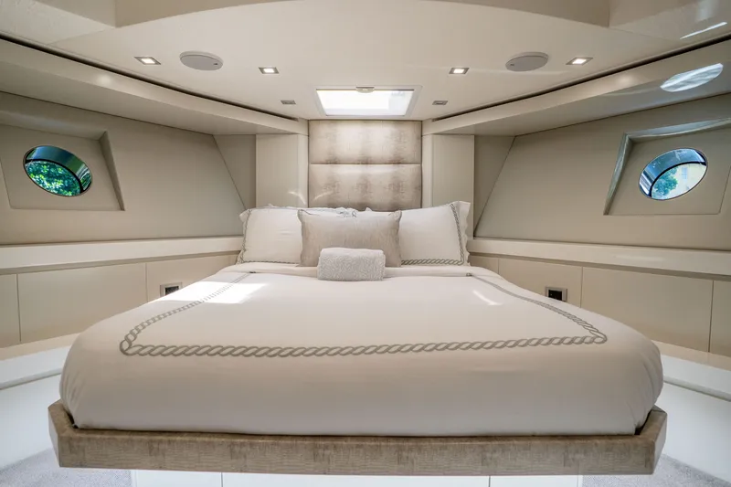 Slide: The Image of Luxurious bedroom interior of 2018 Hatteras M75 Panacera yacht with elegant bedding and porthole windows. - 46
