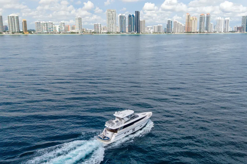 Slide: The Image of 2018 Hatteras M75 Panacera yacht cruising near city skyline on a sunny day. - 7