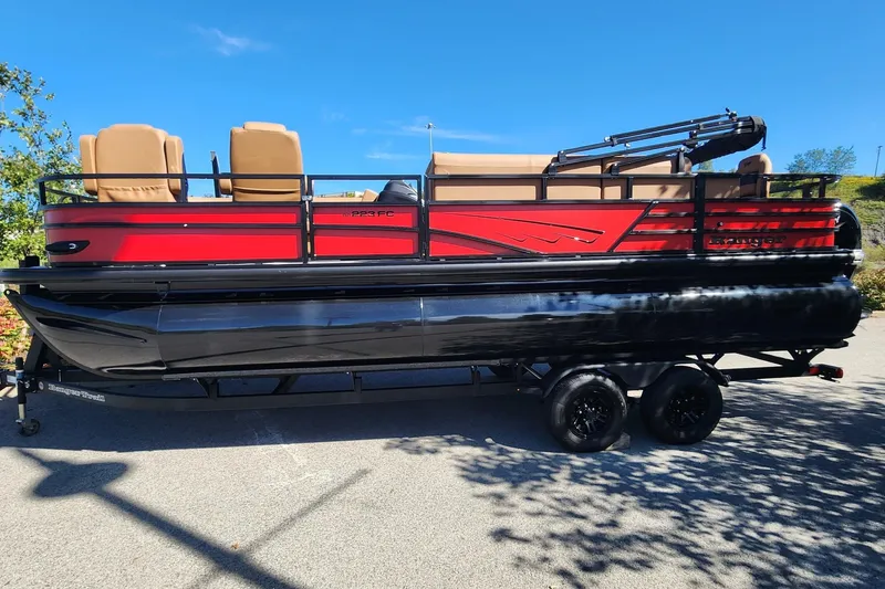Slide: The Image of 2027 Ranger Pontoon 223FC in vibrant red, parked on a trailer under a clear blue sky. - 1