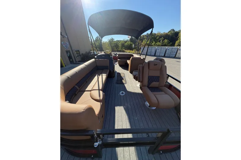 Slide: The Image of 2027 Ranger Pontoon 223FC with spacious seating and canopy, parked outdoors. - 9