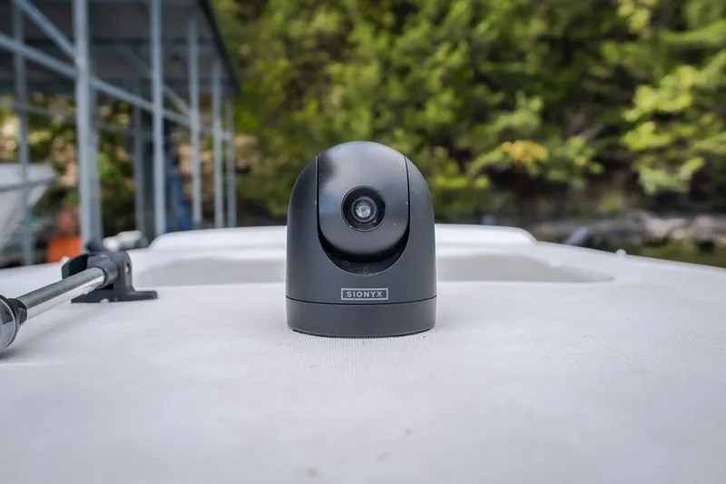 Slide: The Image of Black camera on 2024 Glasstream 32 GSX boat deck, surrounded by greenery. - 55