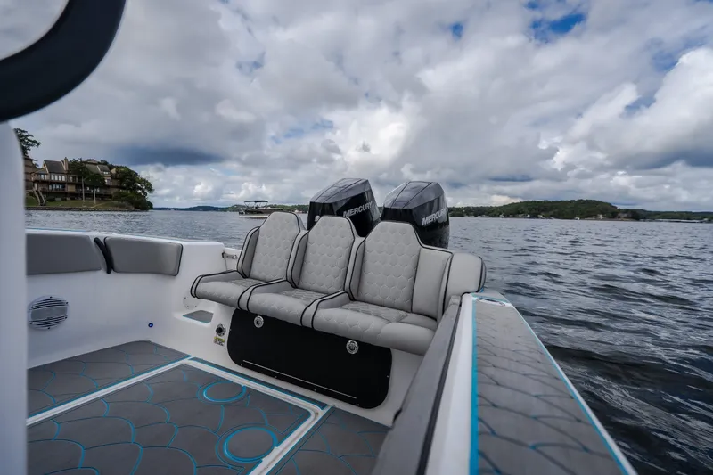 Slide: The Image of 2024 Glasstream 32 GSX boat interior with cushioned seating and twin Mercury engines on a lake. - 13