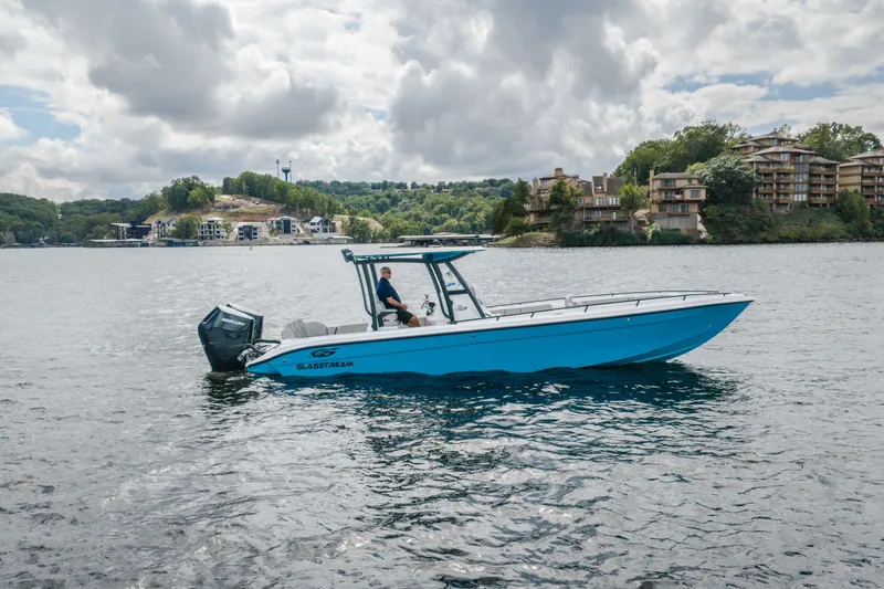 Slide: The Image of 2024 Glasstream 32 GSX boat on a scenic lake with cloudy sky backdrop. - 0