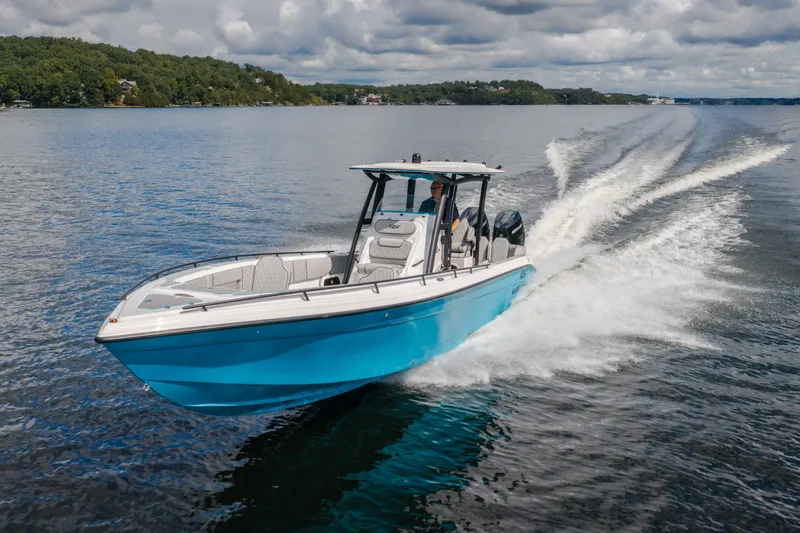 Slide: The Image of 2024 Glasstream 32 GSX boat cruising on a lake under cloudy skies. - 62