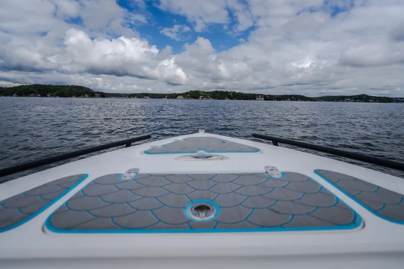 Slide: The Image of 2024 Glasstream 32 GSX boat cruising on a scenic lake under a cloudy sky. - 41