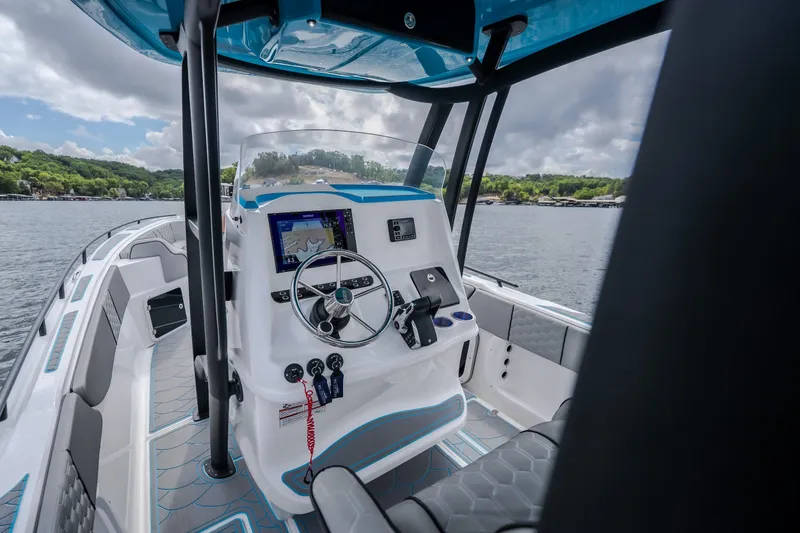 Slide: The Image of 2024 Glasstream 32 GSX boat interior with modern helm and navigation system on a scenic lake. - 50