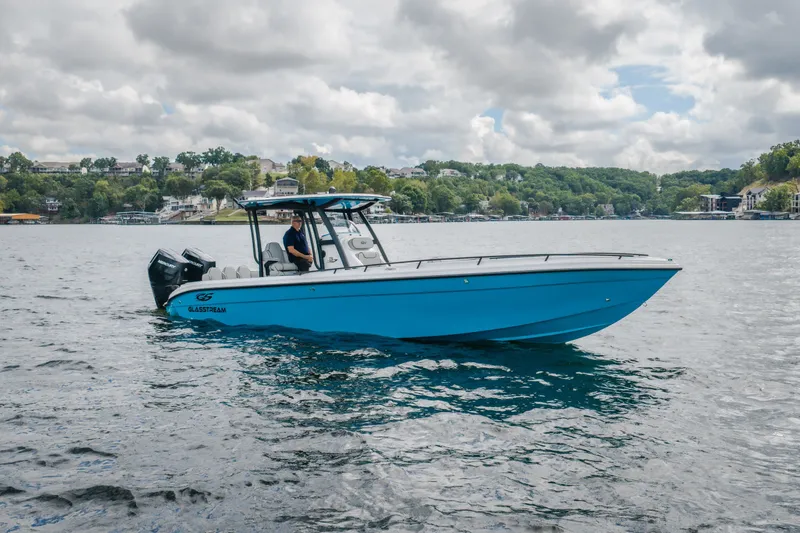 Slide: The Image of 2024 Glasstream 32 GSX boat on a lake with scenic background. - 1