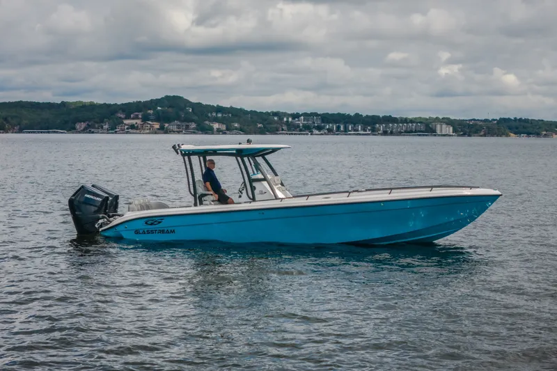 Slide: The Image of 2024 Glasstream 32 GSX boat on calm water, cloudy sky background. - 57