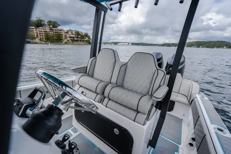 Slide: The Image of 2024 Glasstream 32 GSX boat interior with luxurious seating on a scenic lake. - 19