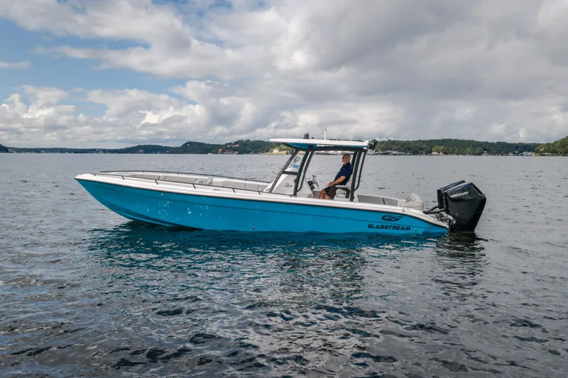 Slide: The Image of 2024 Glasstream 32 GSX boat on a calm lake under cloudy skies. - 8