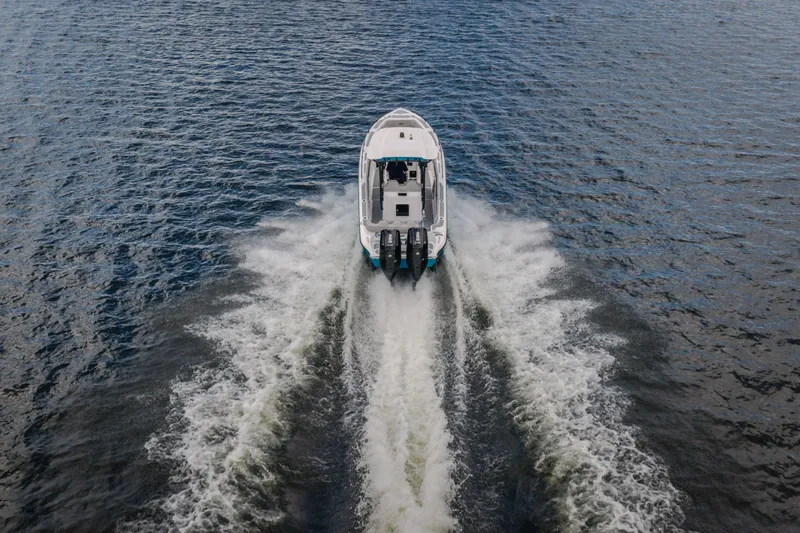 Slide: The Image of 2024 Glasstream 32 GSX boat cruising on open water, aerial rear view. - 61