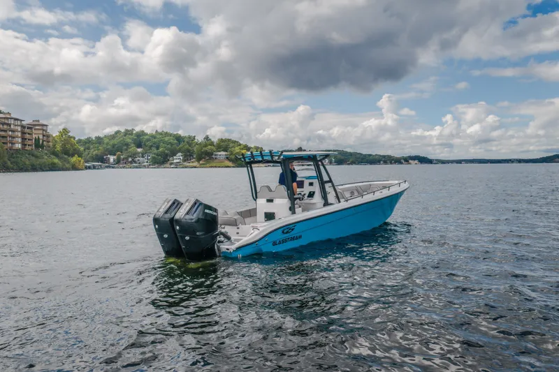 Slide: The Image of 2024 Glasstream 32 GSX boat on a scenic lake with cloudy sky backdrop. - 9