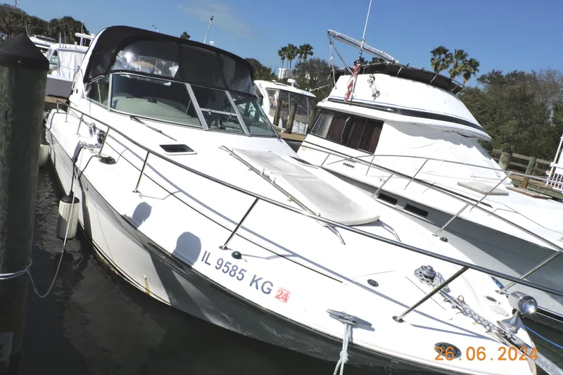 Slide: The Image of 2002 Sea Ray 310 Sundancer docked at marina, sunny day, palm trees in background. - 0