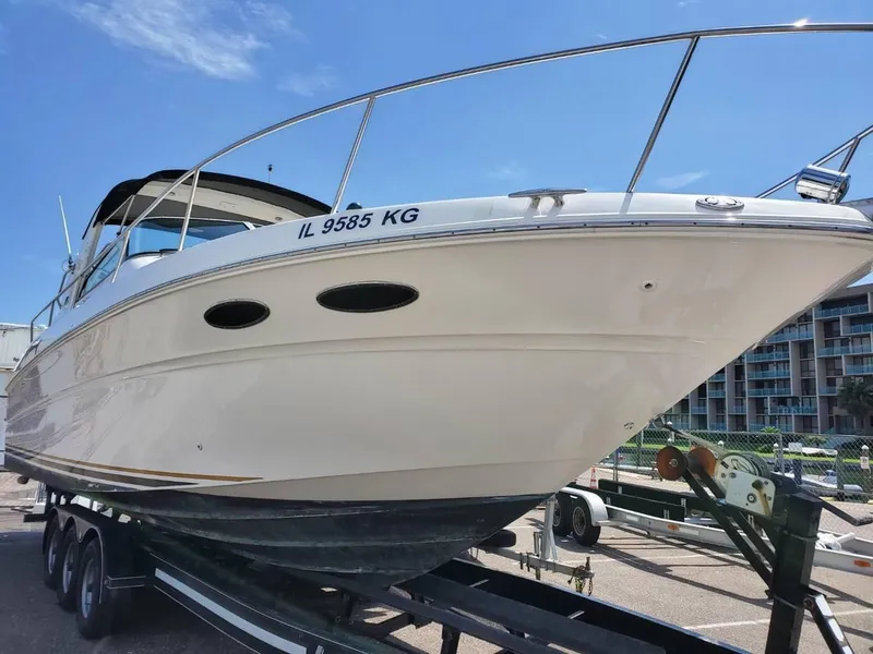 Slide: The Image of 2002 Sea Ray 310 Sundancer boat on trailer under clear blue sky. - 7