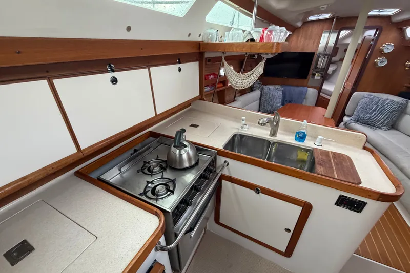 Slide: The Image of Interior of a 1998 Catalina 380 yacht featuring a compact kitchen area. - 22