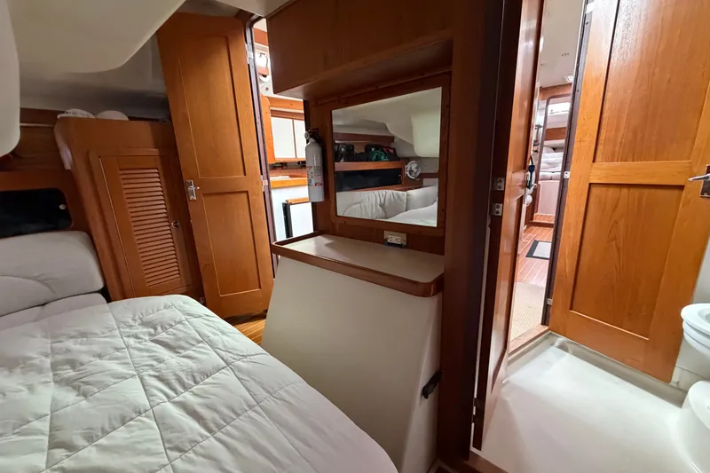 Slide: The Image of Interior of a 1998 Catalina 380 sailboat featuring wood cabinetry and cozy sleeping quarters. - 31