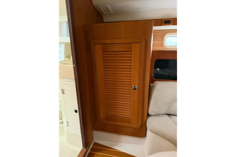 Slide: The Image of Interior of 1998 Catalina 380 sailboat featuring wooden cabinet and seating area. - 35