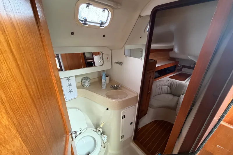 Slide: The Image of Interior of a 1998 Catalina 380 yacht featuring a compact bathroom and cozy cabin space. - 13
