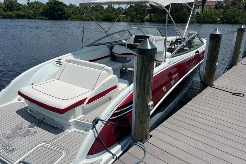 Slide: The Image of 2011 Formula 270 Bowrider docked, featuring sleek red and white design with spacious seating. - 24