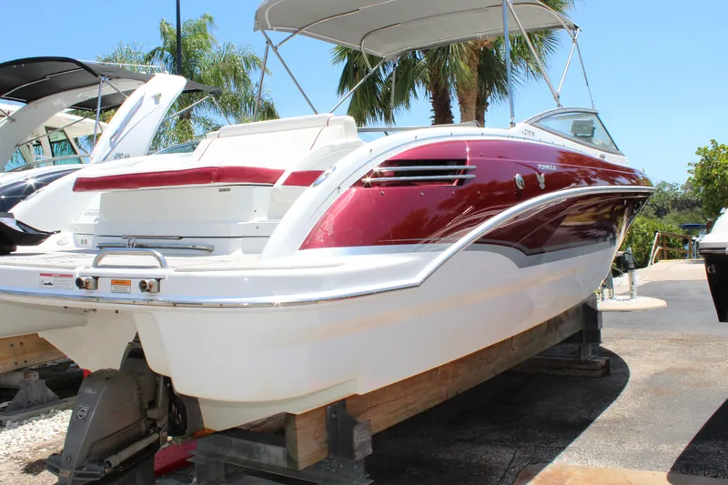 Slide: The Image of 2011 Formula 270 Bowrider boat on dry dock with red and white exterior. - 17