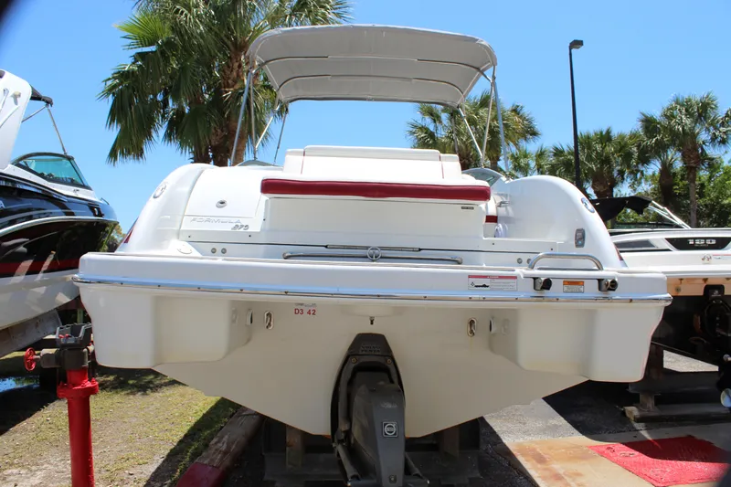 Slide: The Image of 2011 Formula 270 Bowrider boat, rear view, parked on a trailer with palm trees in the background. - 19