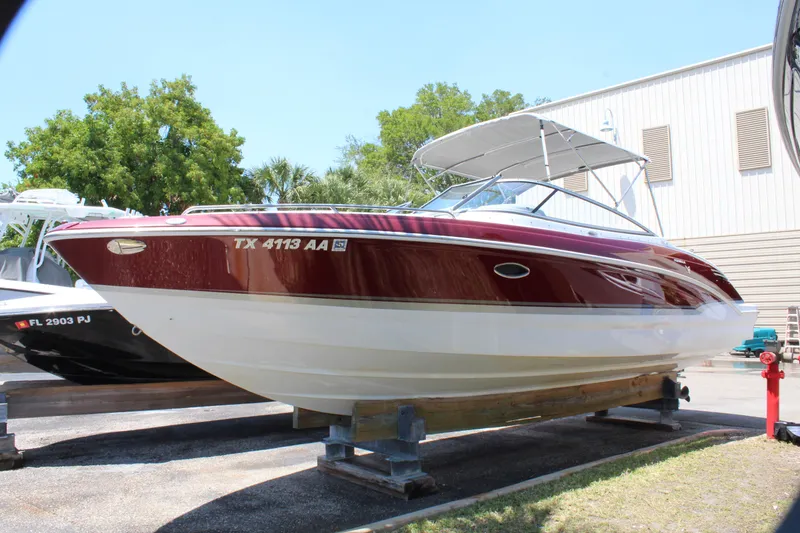 Slide: The Image of 2011 Formula 270 Bowrider boat in red and white, docked on a trailer. - 11
