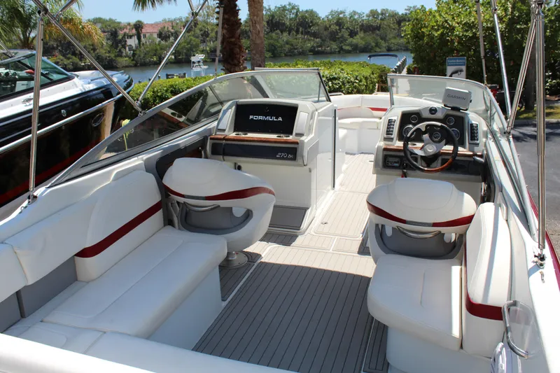 Slide: The Image of 2011 Formula 270 Bowrider boat interior with white and red seating, steering wheel, and dashboard. - 30