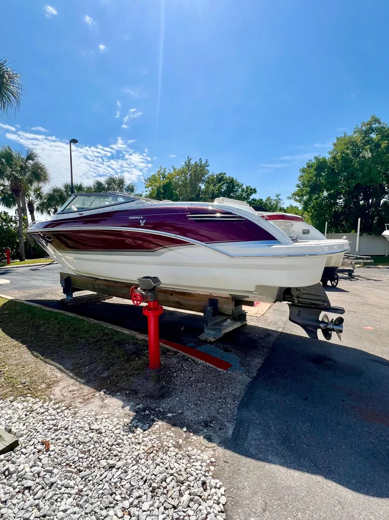 Slide: The Image of 2011 Formula 270 Bowrider boat on a trailer under a clear blue sky. - 14