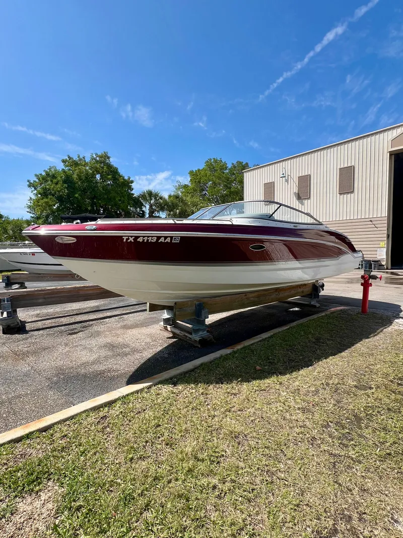 Slide: The Image of 2011 Formula 270 Bowrider boat in red and white, parked outdoors. - 13